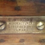 Metal nameplate with screws on wood