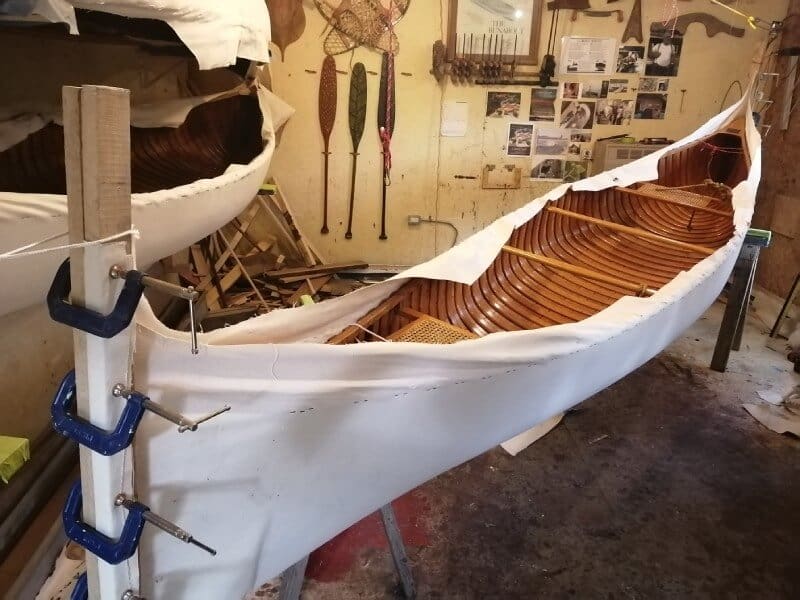 Partially built canoe in woodworking space