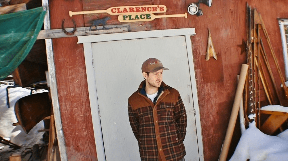 Man standing outside rustic wooden building