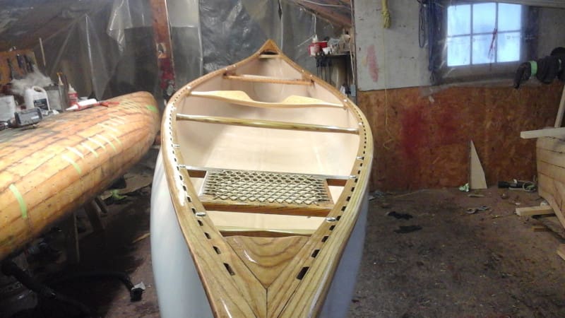 Wooden canoe under construction in workshop.