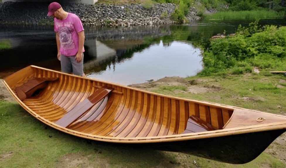 Wooden canoe on grassy riverbank