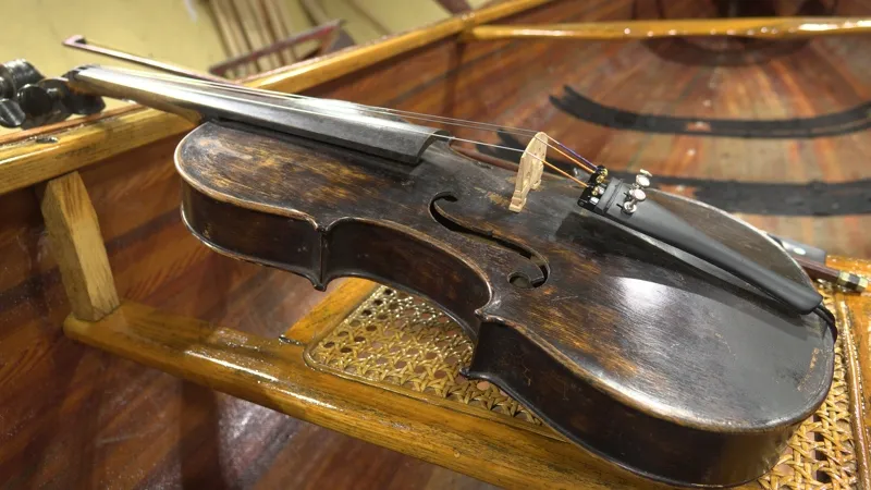 Old violin resting on wooden chair