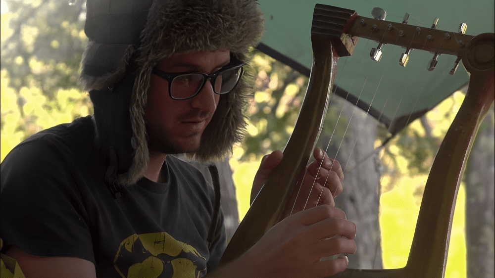 Person strumming strings of a small harp