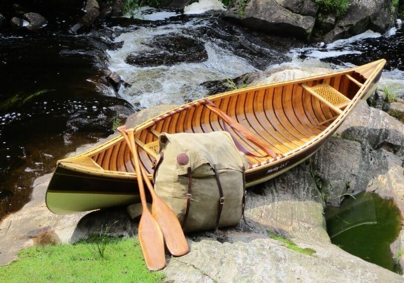 Wooden canoe with paddles on rocks