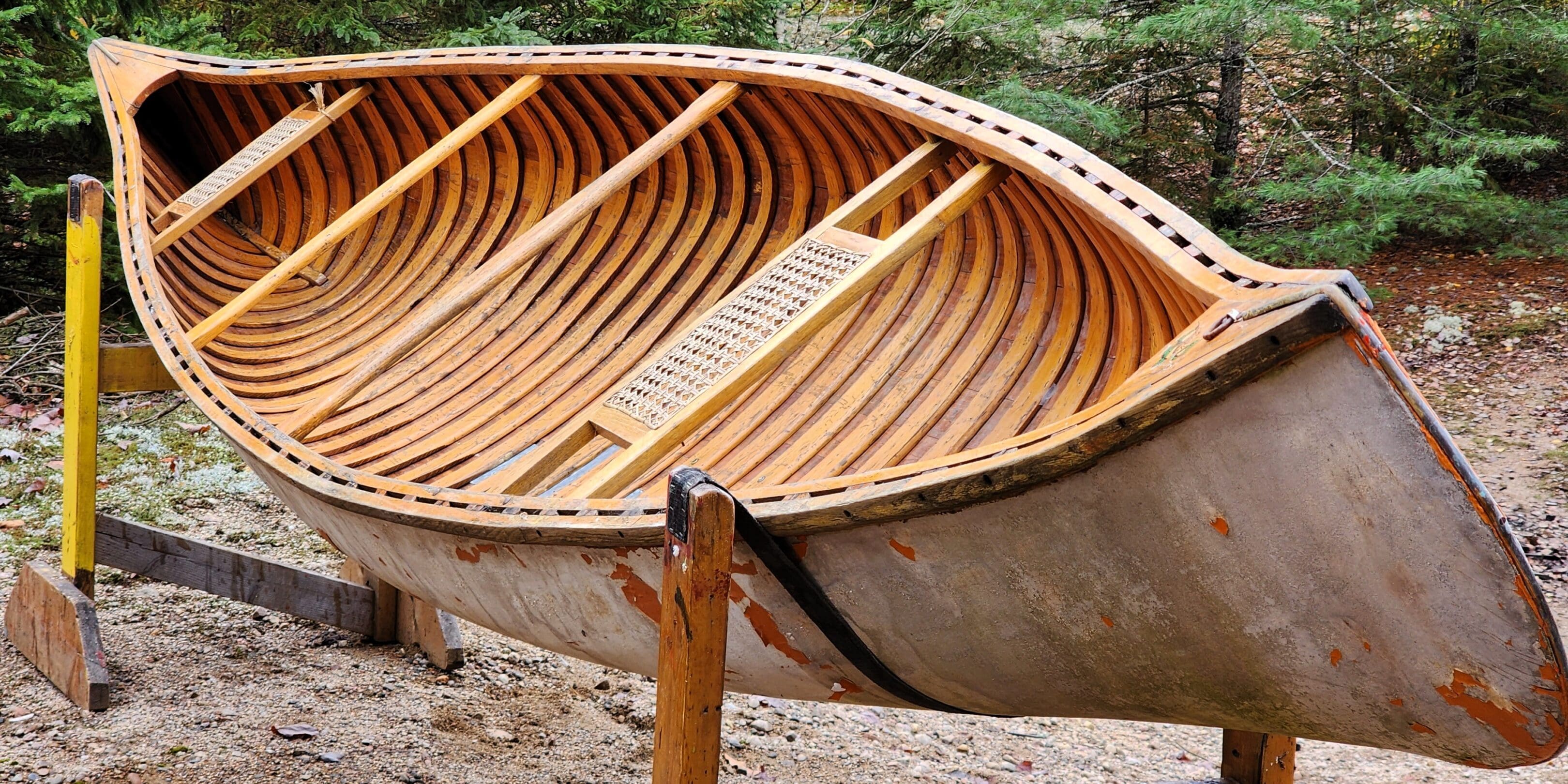 Close-up of the wooden ribs and frame inside a canoe.