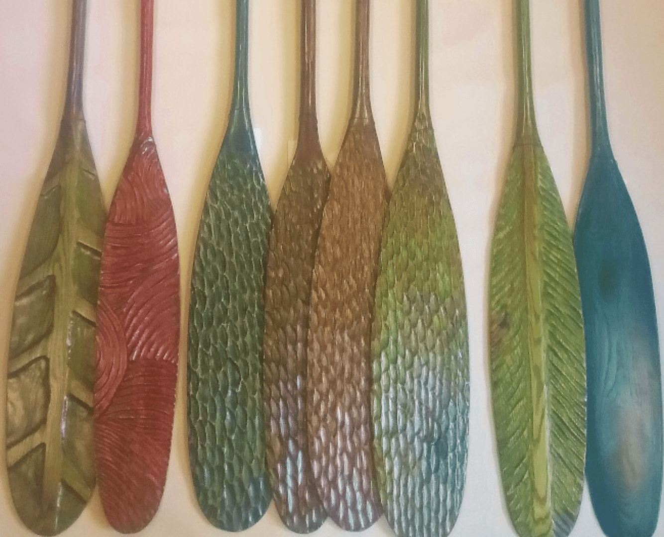 Set of six colorful oars with textured blades.